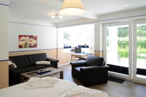 un soggiorno con divano e sedia di Apartments home Wyk auf Föhr - DNS10067-SYA a Wyk auf Föhr