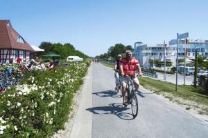 two people riding bikes down a sidewalk at Semi-detached house, Zingst in Zingst