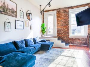 ein Wohnzimmer mit einem blauen Sofa und einer Ziegelwand in der Unterkunft Elegant Old City Loft - Downtown in Knoxville
