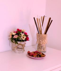 una mesa con dos jarrones de flores y un plato de comida en Hypnos Sleep and Go, en Benevento