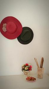 Hypnos Sleep and Go في بينيفنتو: وهناك قبعتان معلقتان على الحائط بجوار طبق من الزهور