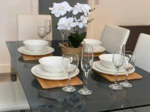 una mesa de comedor con copas de vino y platos en Home from home 2 bed executive style apartment, en Bridgend