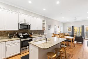 a kitchen with white cabinets and a table and chairs at 113 Waters Edge Community in Folly Beach
