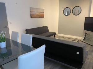 a living room with a glass table and a couch at Comfortable and Modern 2-Bedroom Flat in Bridgend in Bridgend