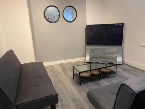 sala de estar con sofá y TV de pantalla plana en Home from home 2 bed executive style apartment, en Bridgend