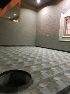 a room with a stone floor with a fire pit at مجمع الضيف السكني in Khamis Mushayt