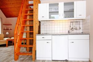 a kitchen with white cabinets and a ladder at Holiday home in Markgrafenheide with paid sauna in Markgrafenheide