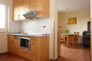 a kitchen with wooden cabinets and a table with a sink at Doppelhaushälfte, Kühlungsborn in Kühlungsborn