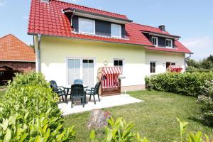a house with chairs and a table in the yard at Doppelhaushälfte, Kühlungsborn in Kühlungsborn