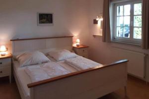 a bedroom with a large white bed with two lamps at Apartments Blue House, Putbus in Putbus