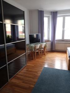 a living room with a television and a table with chairs at Green Apartment House in Bielsko-Biała