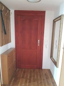 a red door in a room with a wooden floor at Green Apartment House in Bielsko-Biała