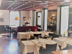a dining room with tables and chairs with white table cloth at Hotel Schwanen Wil in Wil