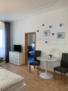 Zimmer mit einem Tisch und Stühlen sowie einem Schlafzimmer in der Unterkunft Nathalie Leser in Baden-Baden