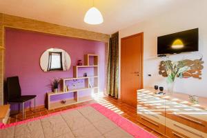 ein Wohnzimmer mit lila Wänden und einem Spiegel in der Unterkunft Holiday home, Francavilla di Sicilia in Francavilla di Sicilia