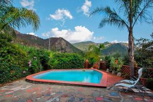 einen Pool mit Palmen und Bergen im Hintergrund in der Unterkunft Holiday home, Francavilla di Sicilia in Francavilla di Sicilia
