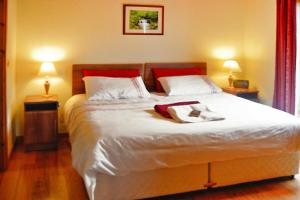 a bedroom with a large white bed with two lamps at Cottage, Manorhamilton in Manorhamilton