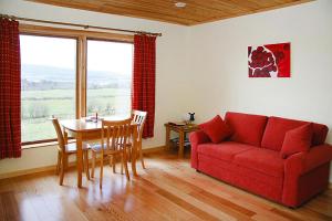 a living room with a red couch and a table at Cottage, Manorhamilton in Manorhamilton