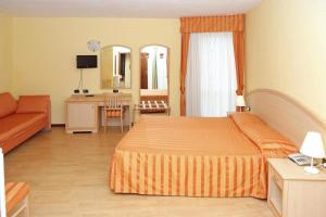 pokój hotelowy z łóżkiem i kanapą w obiekcie Apartment in the Residence dei Fiori, Baveno w mieście Baveno +12 zdjęć