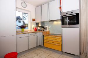 a small kitchen with white cabinets and a window at House, Zirchow Usedom in Zirchow