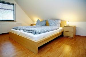 a bedroom with a bed with blue pillows on it at Holiday home Kiebitz, Plau am See in Plau am See