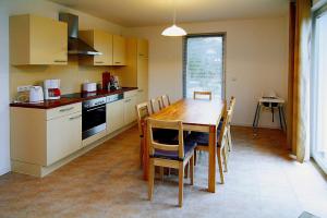 a kitchen with a wooden table and a table and chairs at Holiday home Kiebitz, Plau am See in Plau am See