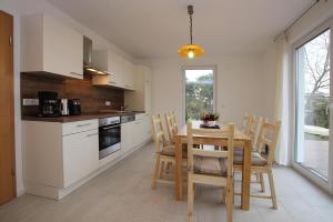 cocina y comedor con mesa y sillas en Holiday home Kiebitz, Plau am See, en Plau am See