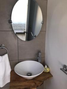 a bathroom with a white sink and a mirror at Cabañas Kalfu Lodge in Vilches