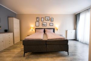 ein Schlafzimmer mit einem großen Bett mit Bildern an der Wand in der Unterkunft BoRa Apartment in Villach