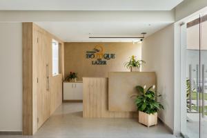 a lobby with potted plants and a sign on the wall at Pousada Boutique do lazer in Cabo Frio