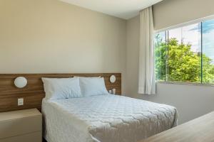 a bedroom with a bed and a large window at Pousada Boutique do lazer in Cabo Frio