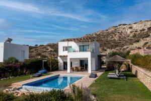 a villa with a swimming pool and a house at The Three Graces in Antimácheia