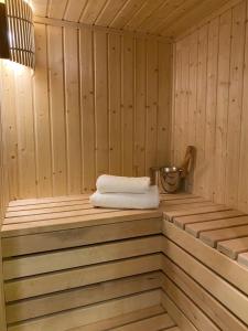 - un sauna avec une serviette assise sur une étagère en bois dans l'établissement Family & Business Sauna Apartments No15 Leśny nad Zalewem Cedzyna Unikat - 3 Bedroom with Private Sauna, Bath with Hydromassage, Terrace, Garage, Catering Options, à Kielce