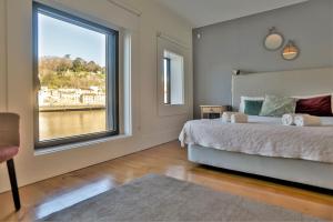 una camera da letto con un letto e una grande finestra di Douro Destilaria Residence by Porto City Hosts a Vila Nova de Gaia