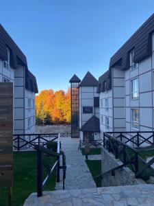 a row of buildings with trees in the background at MIR i LIRA apartmani Kopaonik in Kopaonik
