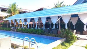 a resort with a swimming pool and a building at Hotel la Cueva Limon in Puerto Limón