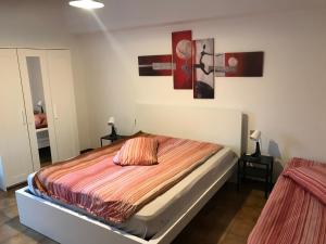 a bedroom with a bed and two paintings on the wall at Appartamento Michela CIPAT 022183-AT-059221 in Darzo