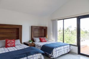 a bedroom with two beds and a large window at Villas La Marina in Cancún +107 photos