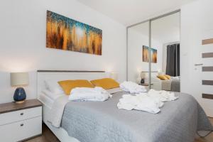sypialnia z łóżkiem z białymi ręcznikami w obiekcie Apartaments SWEET HOME AQUA & SPA w Kołobrzegu