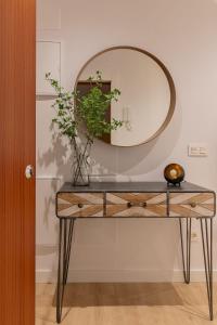 a table with a mirror and a plant on it at Room4You Oviedo by Asturias Holidays in Oviedo
