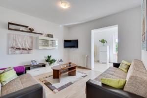 a living room with two couches and a table at Apartments Juric in Rab