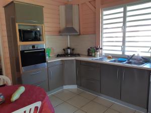 a kitchen with a sink and a stove top oven at Villa havre de paix à Terre de Bas, LES SAINTES in Terre-de-Bas