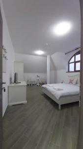 a white bedroom with a bed and a window at Maramures BELVEDERE in Petrova