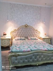 a bedroom with a large bed and two tables at Large Green Apartment in Oral