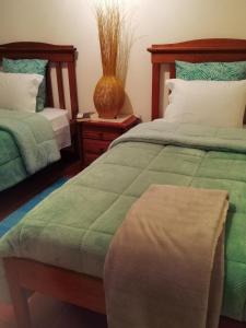 1 Schlafzimmer mit 2 Betten und einer Vase auf dem Tisch in der Unterkunft Casa "Quinta Souto da Ordem" in Castelo Novo