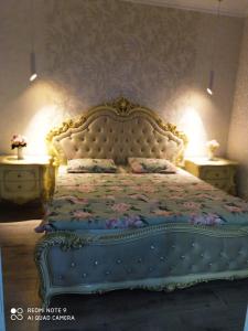 1 dormitorio con 1 cama grande con colcha de flores en Green Apartment en Oral