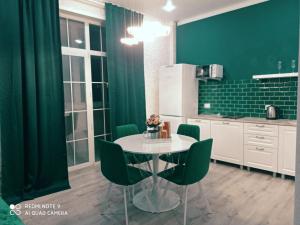 cocina con mesa y paredes verdes en Green Apartment en Oral