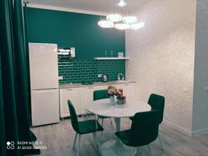 a kitchen with a table with chairs and a refrigerator at Large Green Apartment in Oral