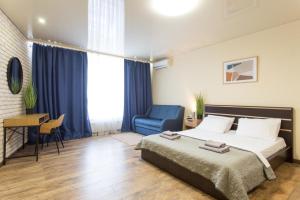 a hotel room with a bed and a blue chair at Studio with an amazing view - 15th floor in Kharkiv