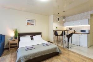 a bedroom with a large bed and a kitchen at Studio with an amazing view - 15th floor in Kharkiv